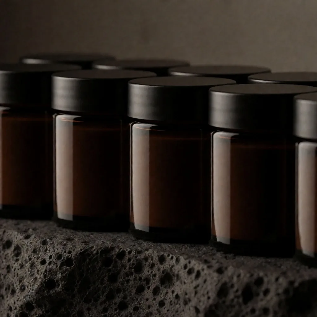 Dark amber supplement bottles arranged on a charcoal stone surface